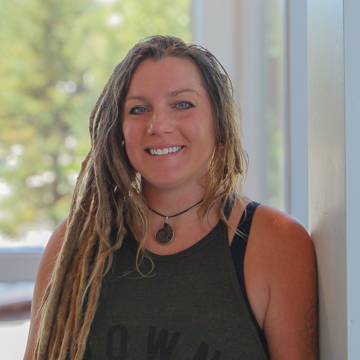 Female massage therapist wearing a necklace and green tank top