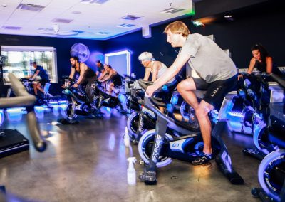 Class attendees spin on stationary bikes during a spin class.