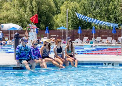 A family sits on the edge of the pool and soaks their feet in the warm hot springs water.