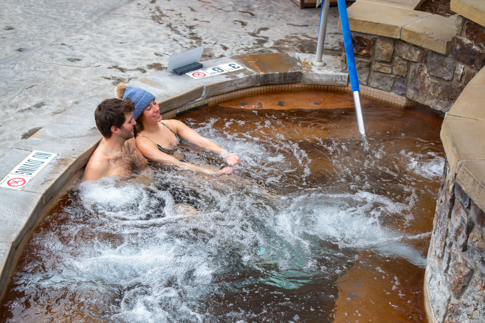 spa one A couple enjoys a relaxing soak in a snall natural hot springs pool.