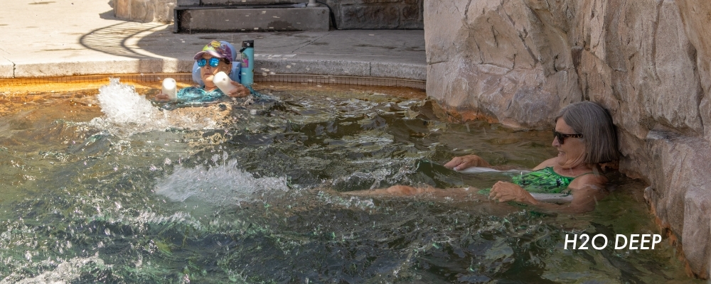 Two women in the water exercise by kicking in the H2O Deep Aqua Class
