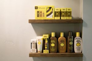 Sun Bum sunscreen lotions, sprays, oil protectants, and hair care on wooden shelves.