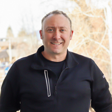 Male massage therapist, John LaBounta poses for headshot in black shirt